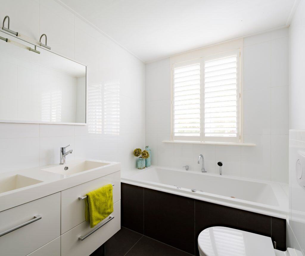 Showing basswood shutters in a bright bathroom providing privacy and natural light with clean design.
