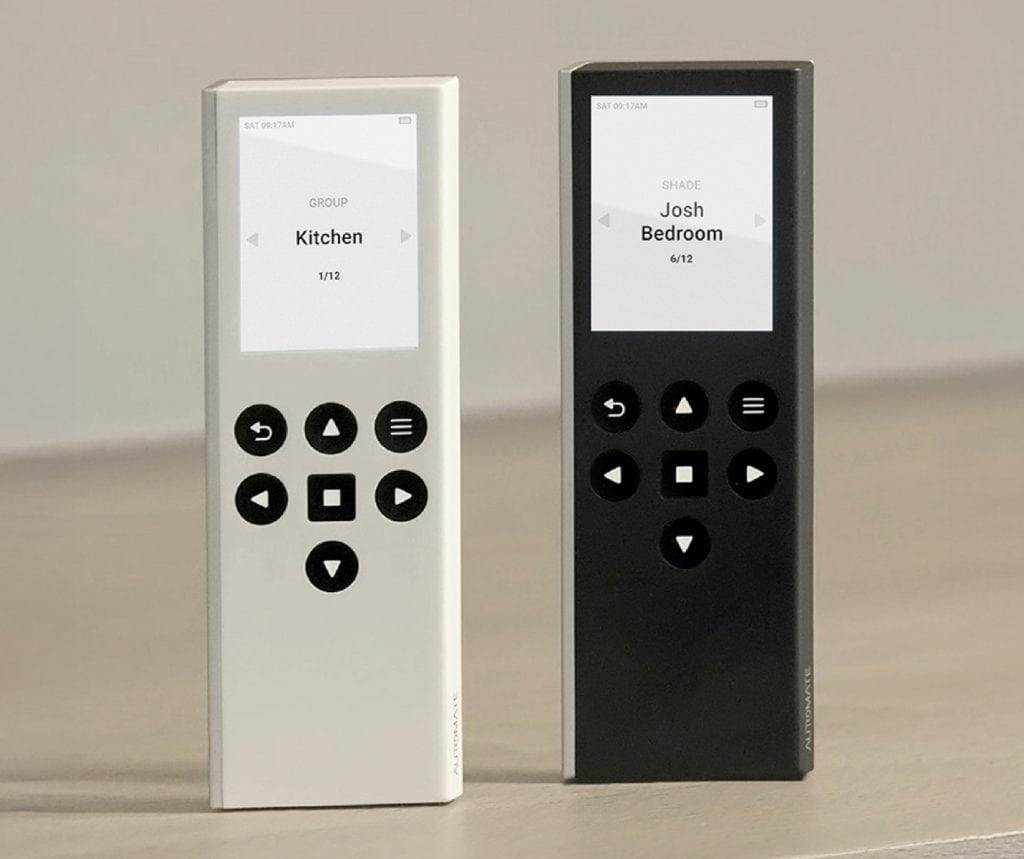 Showing two automated shades remotes, one white and one black, resting on a table