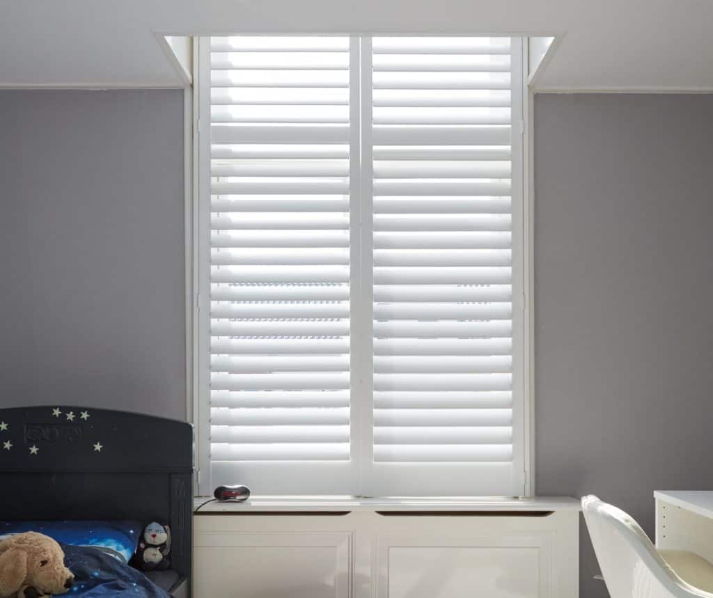 Showing engineered timber shutters in a softly lit bedroom with modern neutral walls.