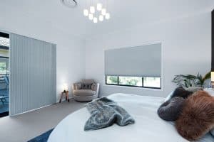 Showing a modern bedroom with grey honeycomb blinds and neutral decor tones.