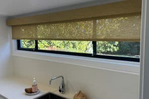Showing modern kitchen roller blinds over sink with soft filtered light