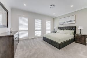 Showing a bedroom with polymer shutters and modern design elements for lasting style.