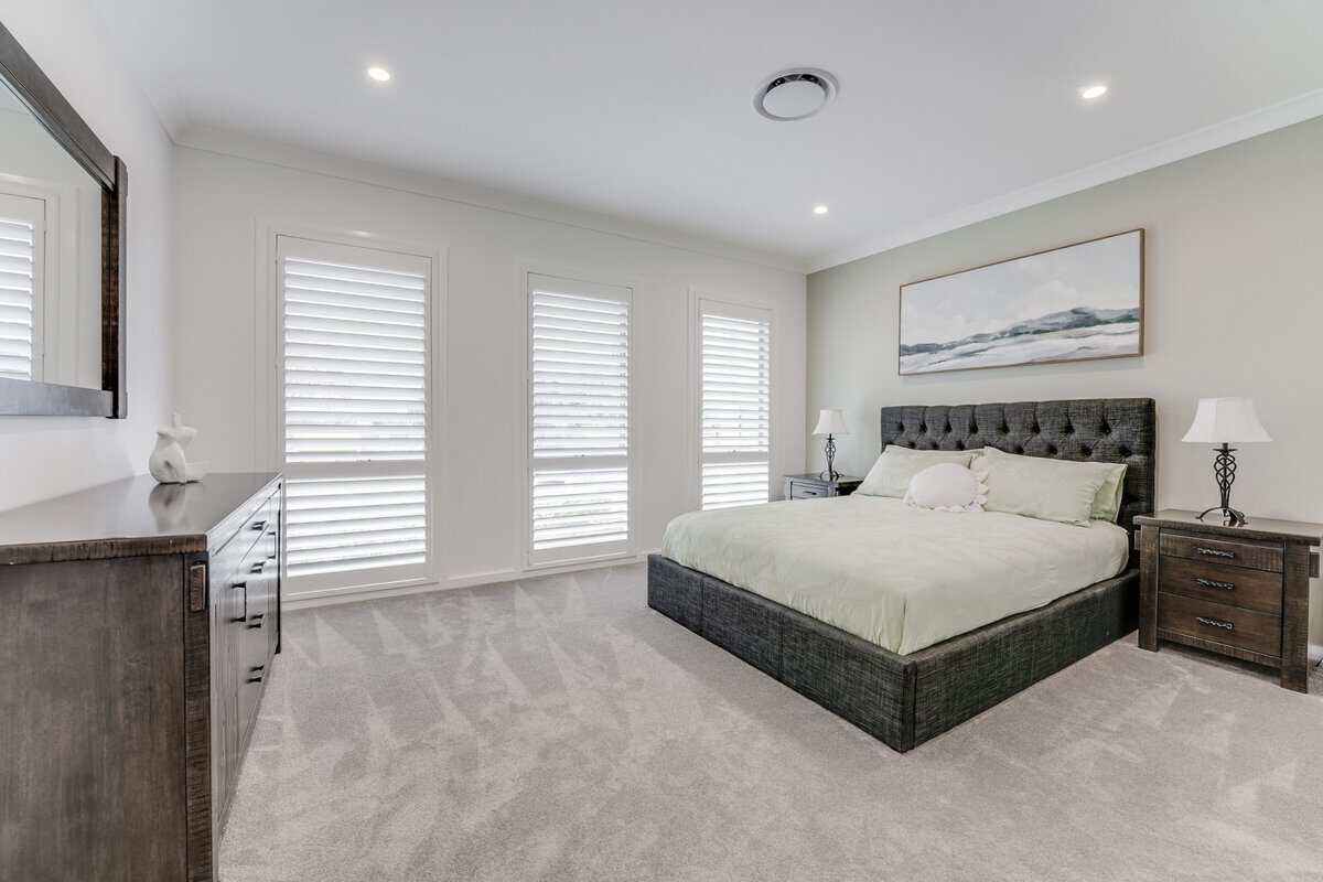 Showing a bedroom with polymer shutters and modern design elements for lasting style.