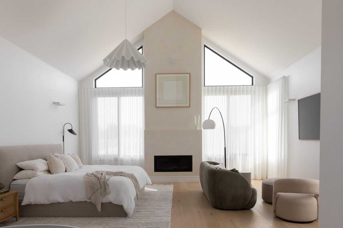 Showing sheer curtains framing tall windows in a modern bedroom with soft natural light.