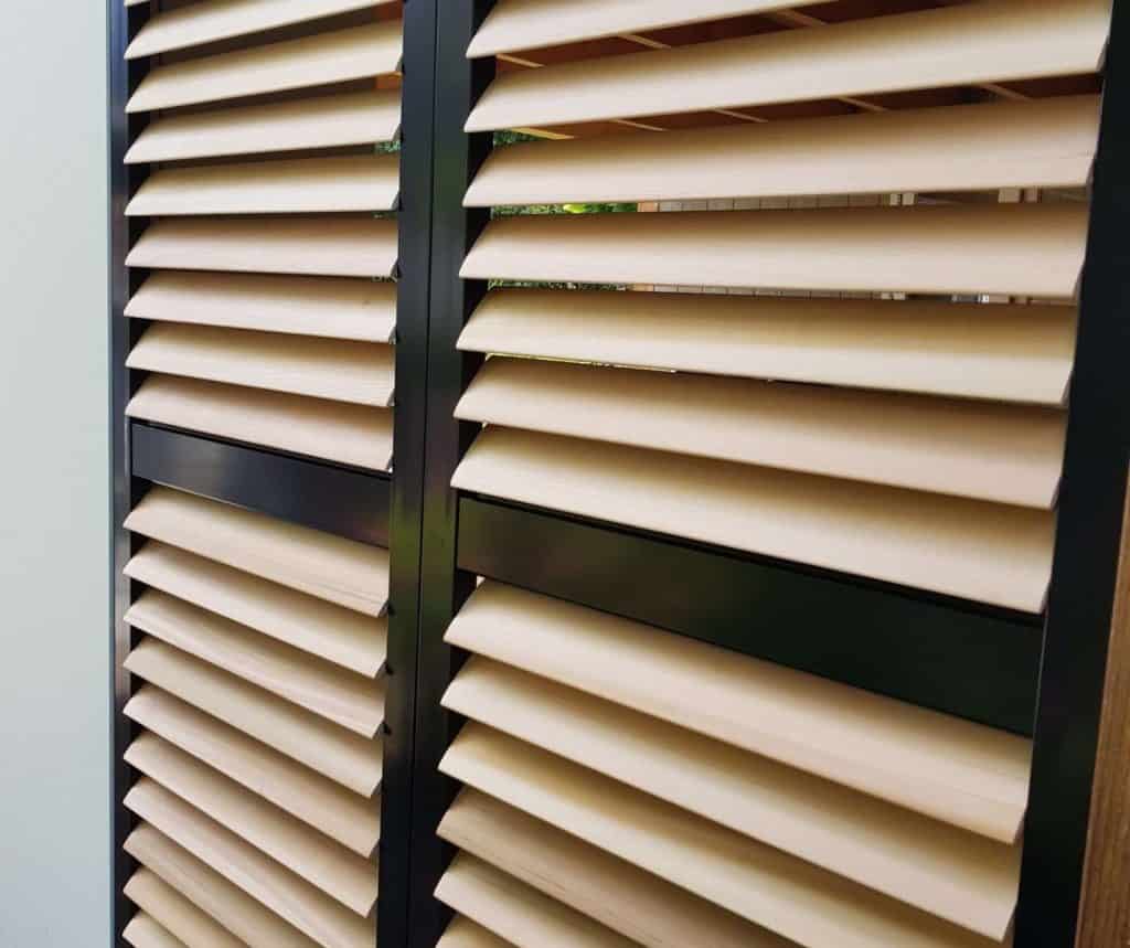 Showing angled cedar shutter blades in black frame with close-up detail view
