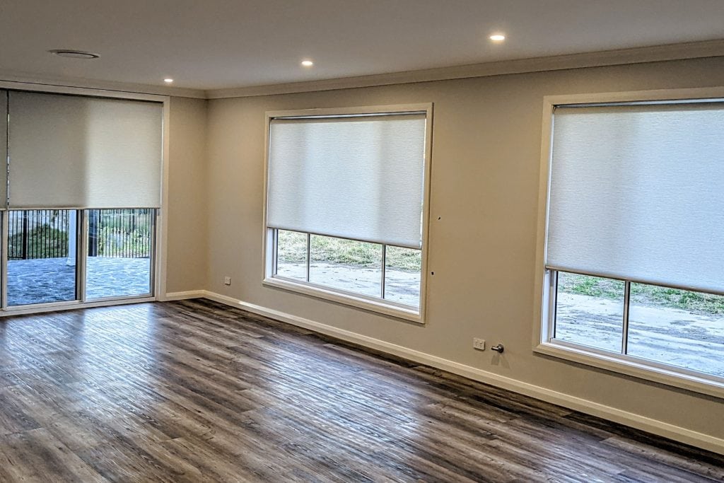 Showing aged care interior with roller blinds over wide windows and timber flooring