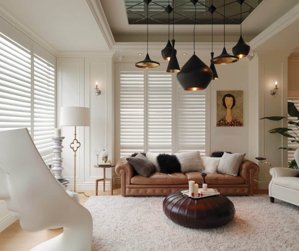 Showing engineered timber shutters in a white lounge room with natural light and soft furnishings