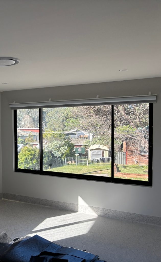 Showing ligature resistant roller blinds above wide windows in care room