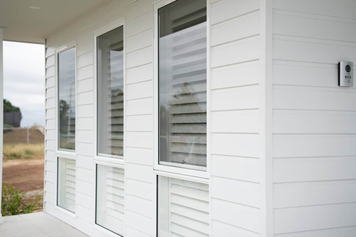 Showing white interior plantation shutters fitted to tall windows, providing privacy, light control and a clean finish.