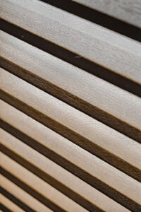Showing the natural woodgrain finish on real timber plantation shutter louvres, highlighting the authentic timber texture and fine grain.
