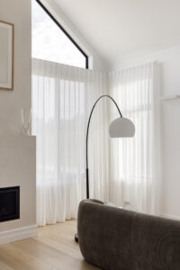 Showing floor-to-ceiling sheer curtains in a modern bedroom, filtering natural light while creating a soft, private and relaxing space.