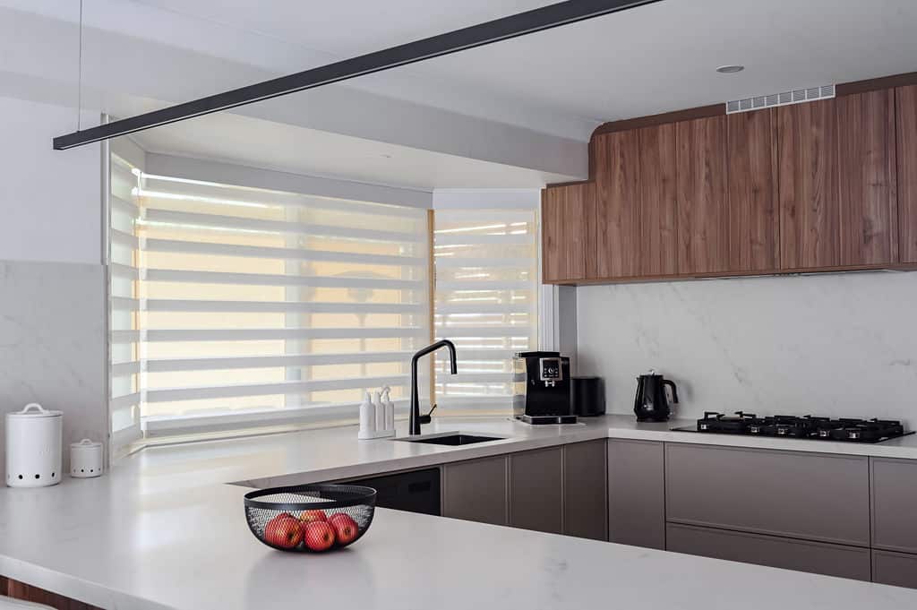 Showing PerfectSheer blinds in a modern kitchen with corner windows, filtered natural light and sleek cabinetry for everyday privacy.