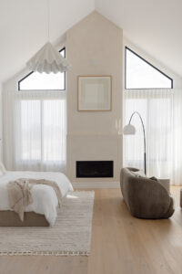 Showing floor-to-ceiling sheer curtains in a modern main bedroom, filtering natural light to create a soft, private and calming retreat
