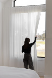 Showing floor-to-ceiling sheer curtains in a modern family home, filtering natural light while providing privacy and a soft interior finish.