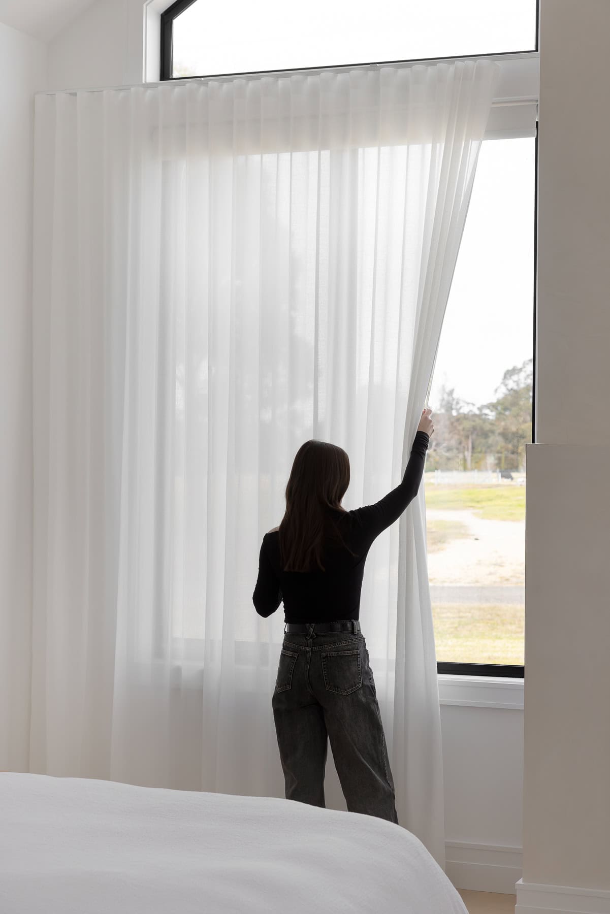 Showing floor-to-ceiling sheer curtains in a modern family home, filtering natural light while providing privacy and a soft interior finish.