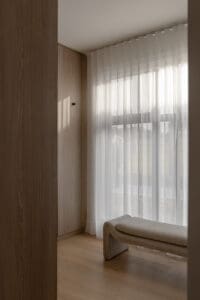 Showing floor-to-ceiling sheer curtains in a modern walk-in robe, filtering natural light to create a soft and private space.