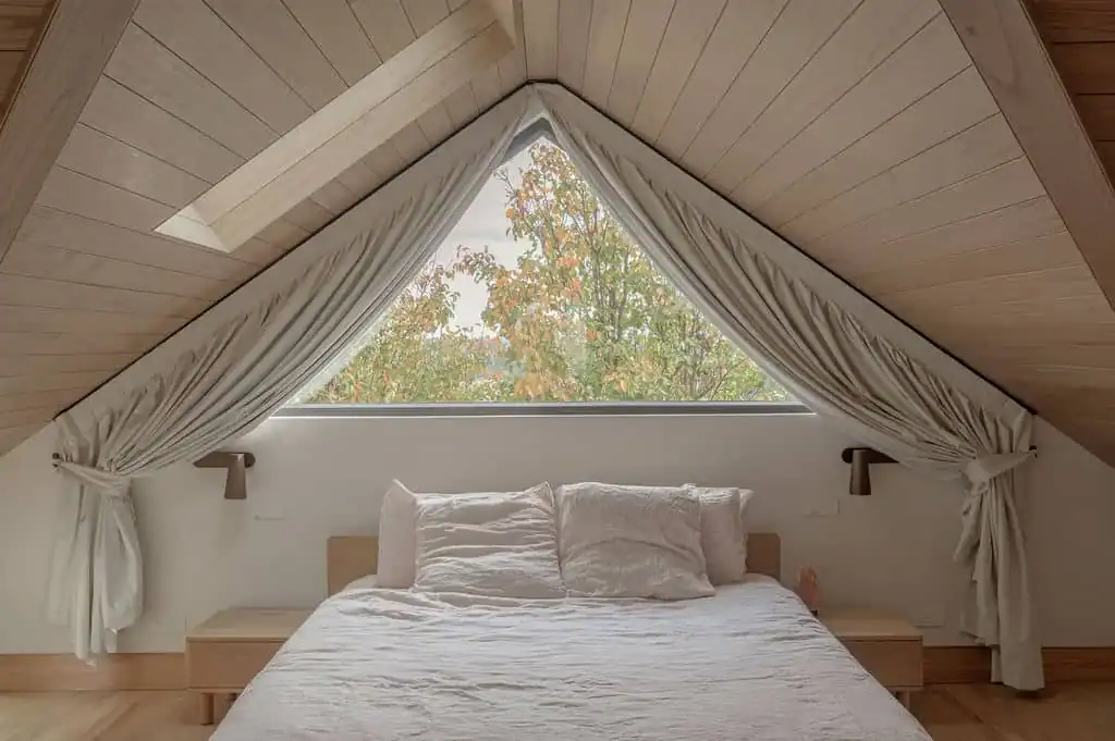Blockout curtains framing a triangular window in a master bedroom, Macarthur
